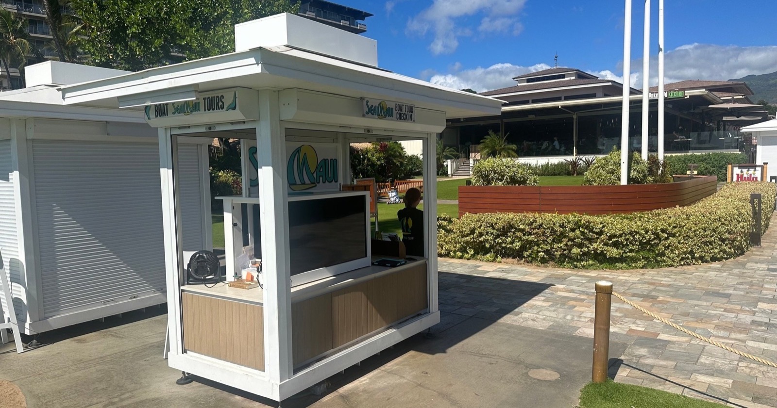 Sea Maui boat tour check-in kiosk on the Whalers Village beach walk with the Hula Grill sign in the background